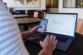 download A person learning stock trading online using a laptop, representing the best online stock trading courses