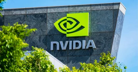 Nvidia headquarters building with green logo on display under blue sky and trees. Ask ChatGPT